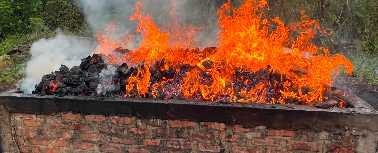 Coconut shells burning inside an open brick kiln