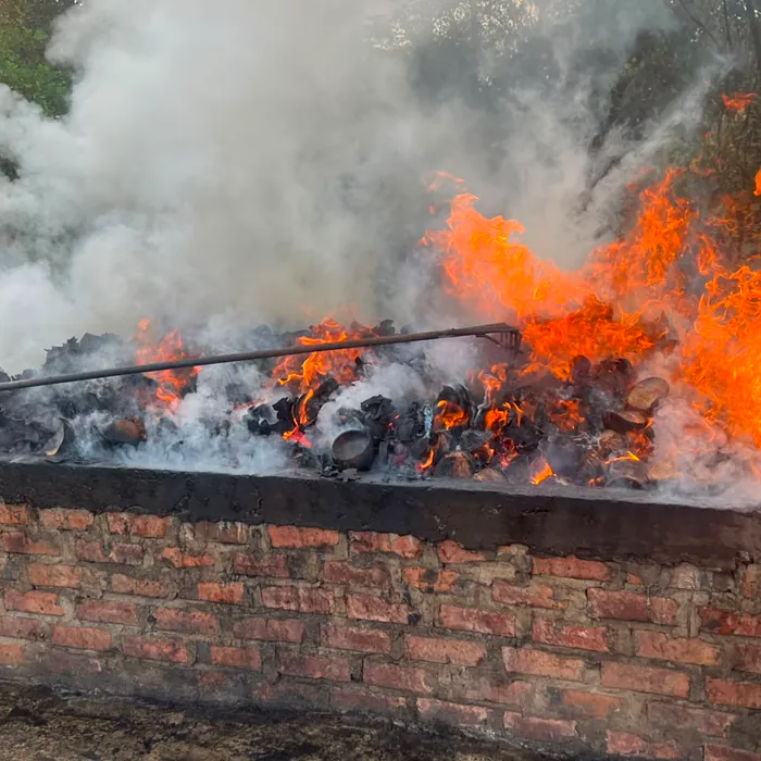 Operator raking shells inside the burning kiln