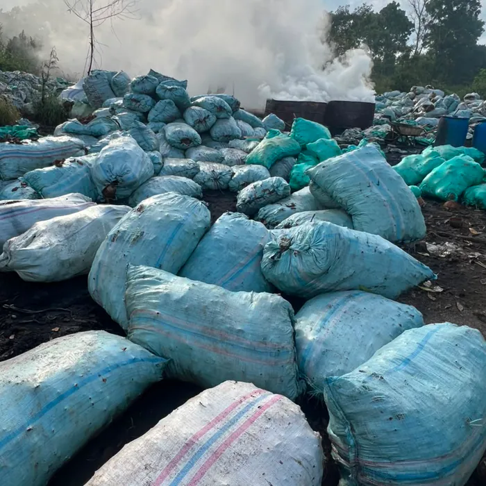 Filled sacks laid out across the yard beside the kiln